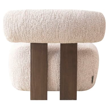 This lounge chair features a low-profile, rounded silhouette upholstered in a textured bouclé fabric. The seat and backrest are generously padded for comfort, with the backrest curving slightly to embrace the user. A dark wood frame is visible behind the upholstered backrest, providing structural support and a visual contrast to the soft upholstery. The chair rests on four short, cylindrical wooden legs, further emphasizing its grounded and sculptural form. — 3D model