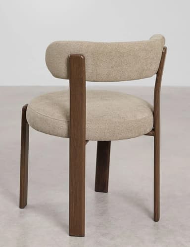 A modern accent chair with a rounded backrest and a circular seat. The frame appears to be constructed from dark wood, with the seat and back upholstered in a textured, neutral-toned fabric. The legs are substantial and slightly angled. — 3D model
