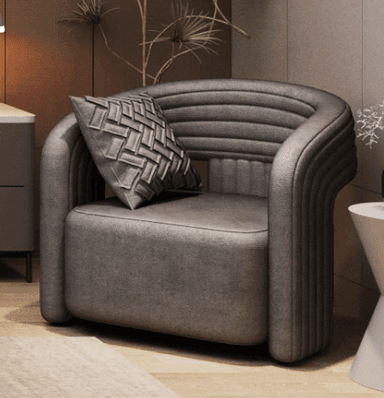 A dark grey upholstered barrel-style accent chair featuring horizontal channel tufting on the curved back and armrests, accompanied by a decorative geometrically patterned throw pillow. — 3D model