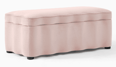 An oblong upholstered storage bench featuring a distinctive scalloped design on both its lift-off top cushion and along the base. The bench is covered in a soft, light pink fabric and rests on four discreet, low-profile black feet. Its top opens to reveal interior storage. — 3D model