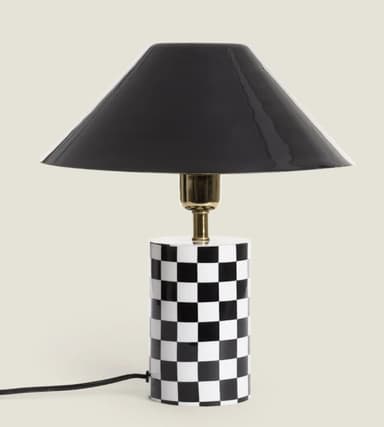 A contemporary table lamp featuring a cylindrical base adorned with a black and white checkerboard pattern, a brass-finished stem, and a glossy black conical shade. — 3D model