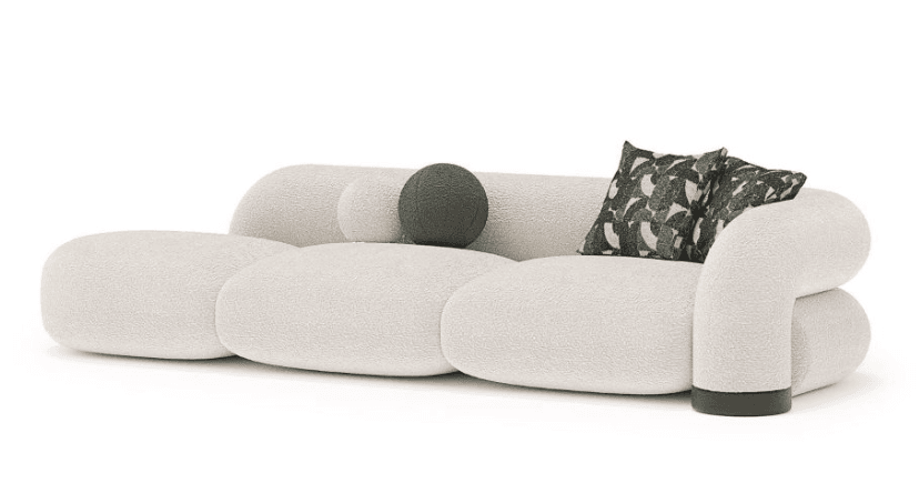 A contemporary curvilinear sofa featuring a low-profile, modular design upholstered in textured off-white bouclé fabric. The sofa comprises several rounded, pill-shaped segments that form the seat, backrest, and integrated armrests. It includes two square throw pillows with a dark green and off-white abstract pattern and one spherical solid dark green pillow. The base of the right armrest has a dark, possibly leather, accent band. — 3D model