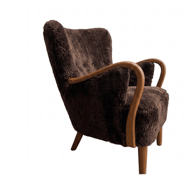 A mid-century modern armchair upholstered in dark brown, shaggy sheepskin or faux fur. It features curved wooden armrests and legs, with a tufted backrest. The chair has a wingback silhouette and tapered legs. — 3D model