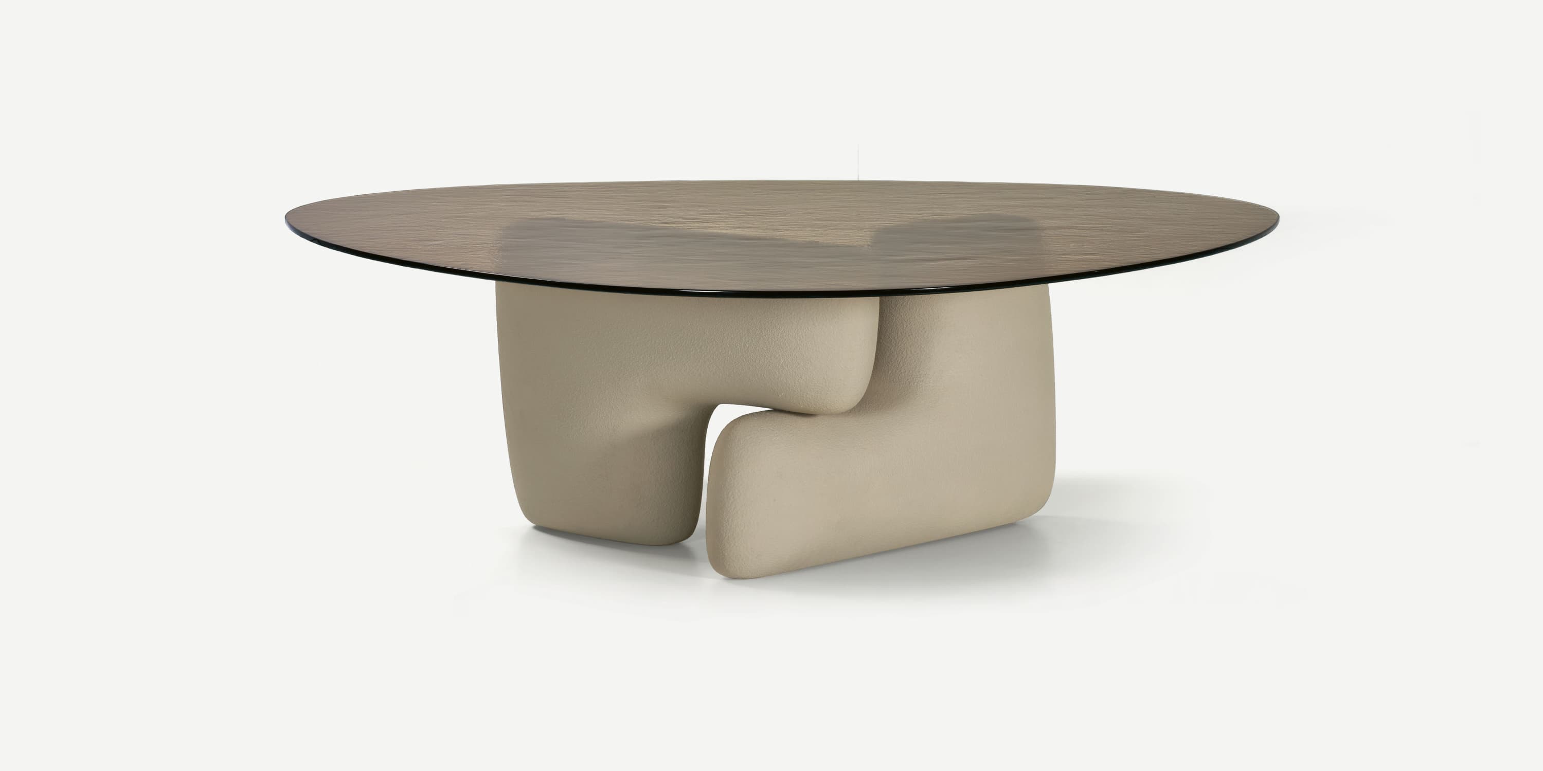 A contemporary coffee table featuring a rounded, asymmetric tabletop made of dark, textured glass, supported by a sculptural base. The base is composed of two intertwined, soft-edged elements that create a unique, organic form. The surface of the base appears to be upholstered or finished with a matte, textured material. — 3D model