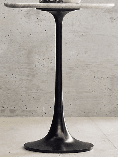 A round side table with a veined marble top supported by a single, fluted pedestal base in black. — 3D model