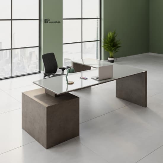 An L-shaped contemporary executive desk featuring a sleek, white tabletop surface that appears to float above a substantial, monolithic base structure. The base has a dark gray, concrete-like finish, providing a striking contrast to the bright, smooth desktop. — 3D model