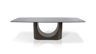A modern dining table with a rectangular, subtly rounded tabletop and a sculptural, single pedestal base. The tabletop has a marble-like pattern with grey and white veining. The base is a dark, matte, curved structure that appears to be U-shaped when viewed from the side. — 3D model