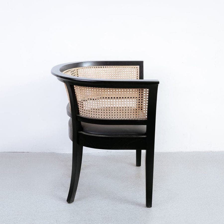 An elegant armchair featuring a black wooden frame with a curved backrest and natural cane webbing. The seat appears to be upholstered in a dark material, likely black leather or fabric. The chair has a classic yet versatile design. — 3D model