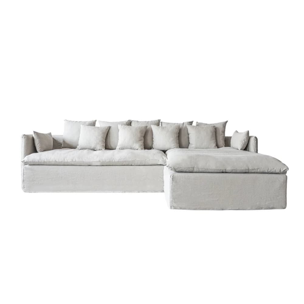 A large, modular sectional sofa with a chaise lounge extension. The sofa features a low-profile design with loose back cushions and bolster pillows on the arms. It is upholstered in a textured, light-colored fabric. — 3D model