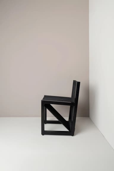 A contemporary chair with a black frame and a seat and backrest constructed from closely spaced black cords or ropes. The cords are stretched vertically across the frame, creating a textured and somewhat visually open surface. The legs are simple, straight, and square in profile. — 3D model