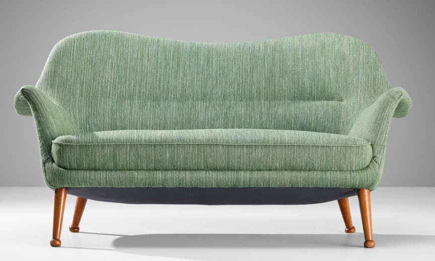 A two-seater sofa with a curvaceous backrest and armrests, upholstered in a textured green fabric. The sofa is supported by four tapered wooden legs that angle outwards. — 3D model