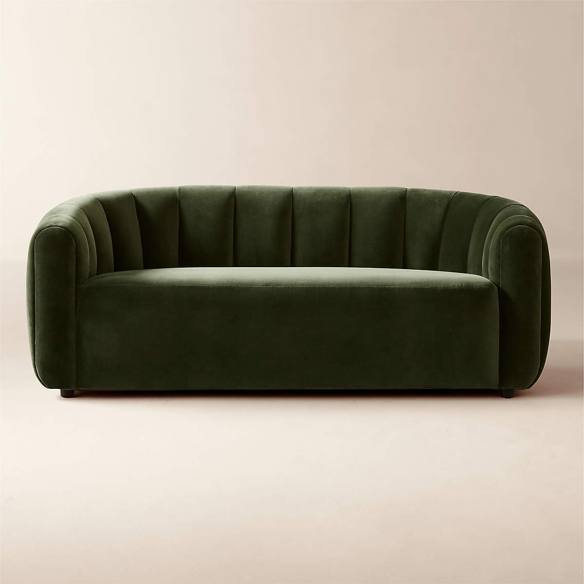 A modern sofa upholstered in deep olive green velvet, featuring a continuous, channel-tufted backrest and broad, rounded armrests that seamlessly flow into the back. The seat cushion is flat and integrated into the overall minimalist design. The sofa has a low profile with a concealed base. — 3D model
