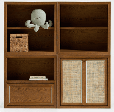 A modern modular storage unit made of medium brown wood, featuring open shelving cubbies in the upper section, a single drawer with small brass knobs, and two cabinet doors with woven cane inserts in the lower section. The wood displays a visible grain pattern, and the unit is presented in an isometric view against a white background. — 3D model