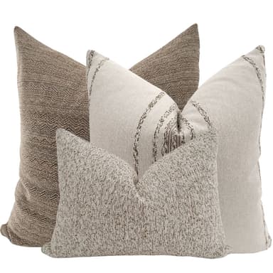 A textured pillow with a speckled pattern, featuring a neutral color palette. It is designed with a slight taper towards the corners, giving it a classic lumbar pillow shape. The fabric appears to be a woven textile. — 3D model