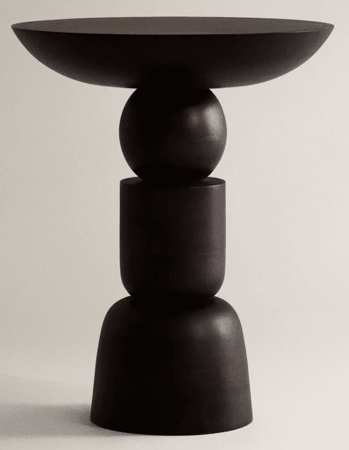 A tall, sculptural pedestal table constructed from dark-stained wood, featuring a base composed of stacked geometric forms including a bell shape, a cylinder, and a sphere, topped with a wide, shallow, concave disc. The overall aesthetic is minimalist and abstract. — 3D model