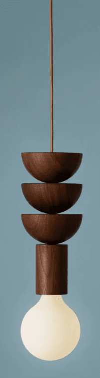 A modern pendant light featuring a series of stacked, half-spherical and cylindrical wooden elements. It hangs from a fabric-wrapped cord, culminating in an exposed, spherical, frosted light bulb at the bottom. The wooden components have a smooth, dark finish. — 3D model