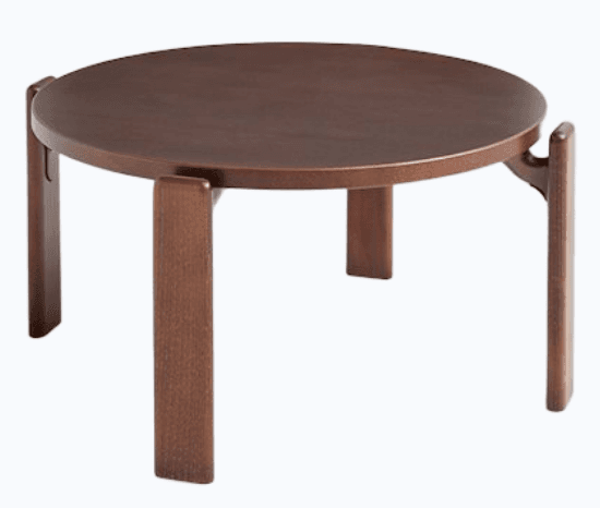 A low, circular coffee table with a dark brown wooden finish. It features four rectangular legs that are inset and connected to the underside of the tabletop with subtle supports. — 3D model