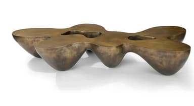 A low-profile, sculptural coffee table with an organic, undulating form and a patinated bronze finish. It features integrated depressions on its surface. — 3D model