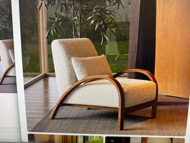 A contemporary lounge chair featuring an off-white boucle upholstered seat and backrest, complemented by a distinctive dark bentwood frame that forms integrated armrests. The chair includes a matching lumbar pillow. — 3D model
