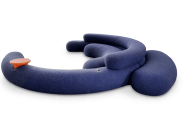 A modular sofa with a curved, organic design. It appears to be upholstered in a soft, textured fabric and features plump, rounded sections that form a seating area. There is a small, circular orange accessory attached to one of the sections, possibly a control or decorative element. The overall form is playful and contemporary. — 3D model