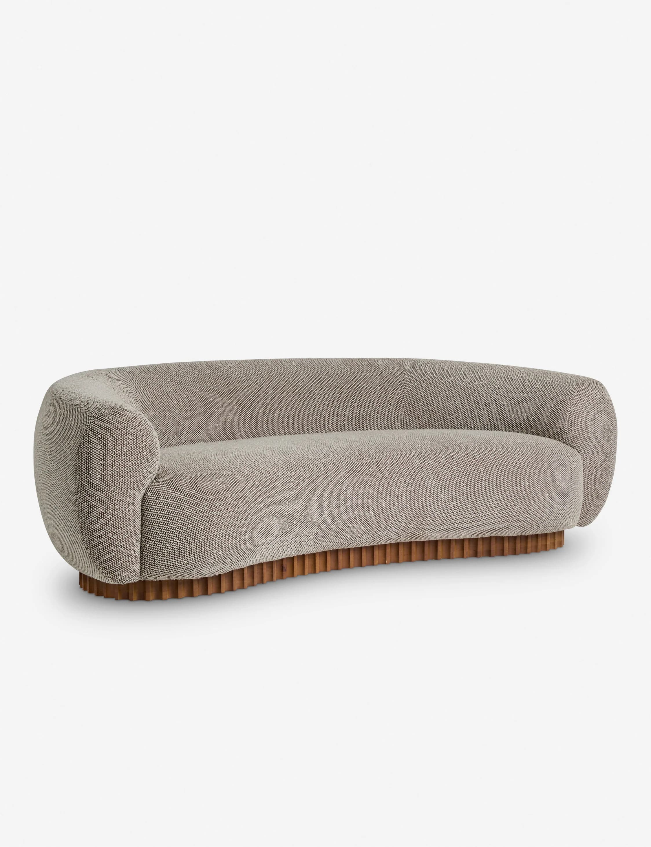 A curved sofa with a rounded silhouette, featuring a textured fabric upholstery and a distinctive wooden base with vertical fluting. The sofa has integrated armrests that flow into the backrest, creating a continuous, organic form. The base is composed of numerous closely spaced, vertical wooden elements. — 3D model