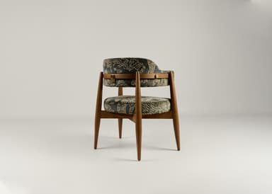 A wooden accent chair with two upholstered seating surfaces. The frame is constructed from light brown wood with tapered legs. The upholstery is a dark fabric with an intricate, possibly embroidered, pattern in a lighter color, featuring scrollwork and geometric motifs. A brass-colored latch or buckle detail is visible on the upper upholstered section. — 3D model