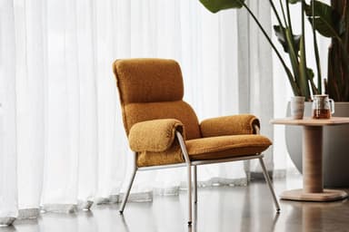 A modern armchair with a high back and padded arms, supported by a slender white metal frame. The upholstery appears to be a textured fabric in a neutral, multi-tonal beige or tan color. — 3D model