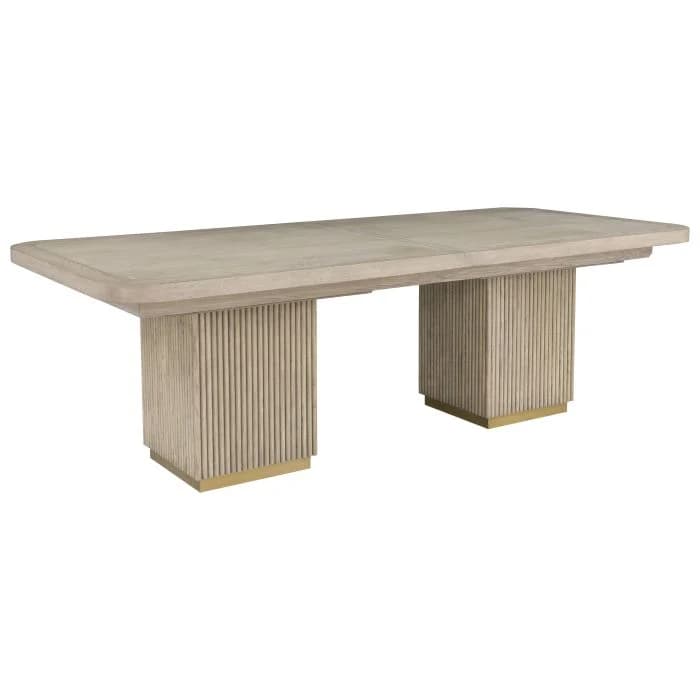 A contemporary rectangular dining table featuring a light-toned wood finish and two substantial fluted pedestal bases, each accented with a brass plinth. — 3D model