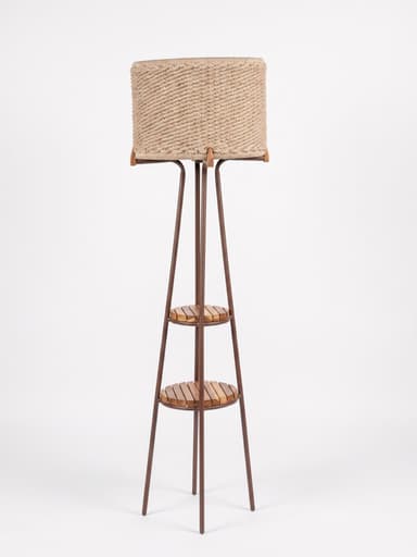 A floor lamp featuring a cylindrical shade made of woven rope-like material, set atop a slender dark metal frame that widens towards the base, incorporating two circular slatted wooden shelves. — 3D model
