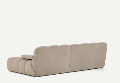 A light beige, modular sectional sofa featuring a chaise lounge component on the right side. The entire sofa is upholstered in a ribbed corduroy fabric, giving it a plush, textured appearance. It consists of deep, blocky cushions for both the seat and backrest, arranged in a low-profile, contemporary style. The armrests are similarly upholstered and integrated, providing a soft, rounded look. — 3D model