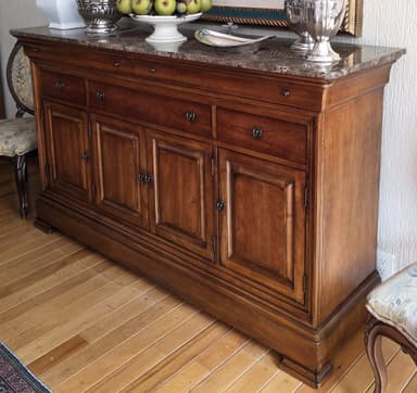 A wooden sideboard with a marble top. It features multiple drawers and cabinet doors with metal hardware. The wood has a warm, medium-brown finish. The marble top has a speckled, grey and brown pattern. The piece has a traditional or classic style, indicated by the paneling on the doors and the molding details. — 3D model