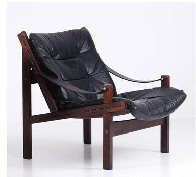 A low-slung lounge chair featuring a dark-stained solid wood frame, likely rosewood, with exposed joinery. It is fitted with thick, tufted black leather cushions for both the seat and back, suspended within the frame. Leather straps form the armrests, secured by brass hardware. — 3D model