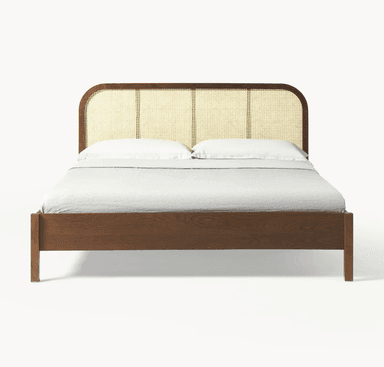 A modern platform bed featuring a dark wood frame and a cane-webbed headboard with rounded corners, complete with bedding. — 3D model