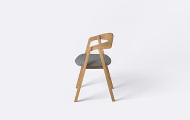 A modern dining armchair featuring a light-toned wooden frame and a grey upholstered seat. The backrest is crafted from bentwood, forming a continuous curve that extends into integrated armrests. The chair is presented against a plain white background, highlighting its clean lines and minimalist design. — 3D model