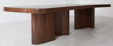 A modern dining table with a rich walnut finish, featuring a rectangular top with softly rounded corners. The table is supported by two distinct, wavy, sculptural pedestal bases, offering a unique and stable foundation. — 3D model