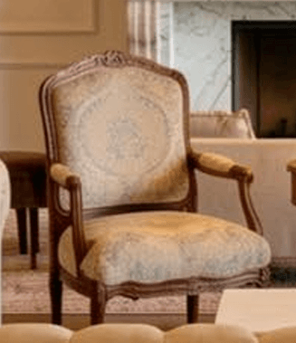 A traditional French Provincial style armchair featuring a carved wooden frame and elaborate upholstery. The chair has a tall, slightly curved back, rolled armrests, and cabriole legs. The fabric is light beige with a subtle, ornate medallion and scrollwork pattern. — 3D model