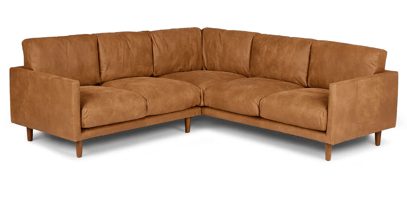 An L-shaped sectional sofa upholstered in a tan or camel-colored distressed leather, featuring clean lines and a modern aesthetic. It comprises multiple connected modules, forming a corner configuration, with loose seat and back cushions, block arms, and tapered wooden legs. — 3D model