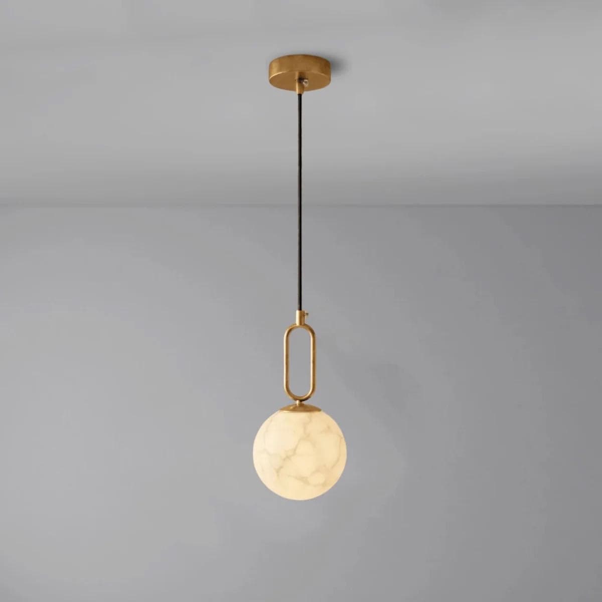 A modern pendant light featuring a brass-finished canopy and frame, supporting a spherical shade with a white marble-like pattern. — 3D model