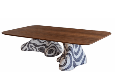 A low-profile coffee table with a distinct base. The tabletop is a rectangular slab with gently rounded corners, constructed from a warm-toned wood. The base is sculptural and appears to be made of a mosaic material, featuring an abstract, wavy pattern in black and white. The overall form suggests a modern or eclectic design aesthetic. — 3D model
