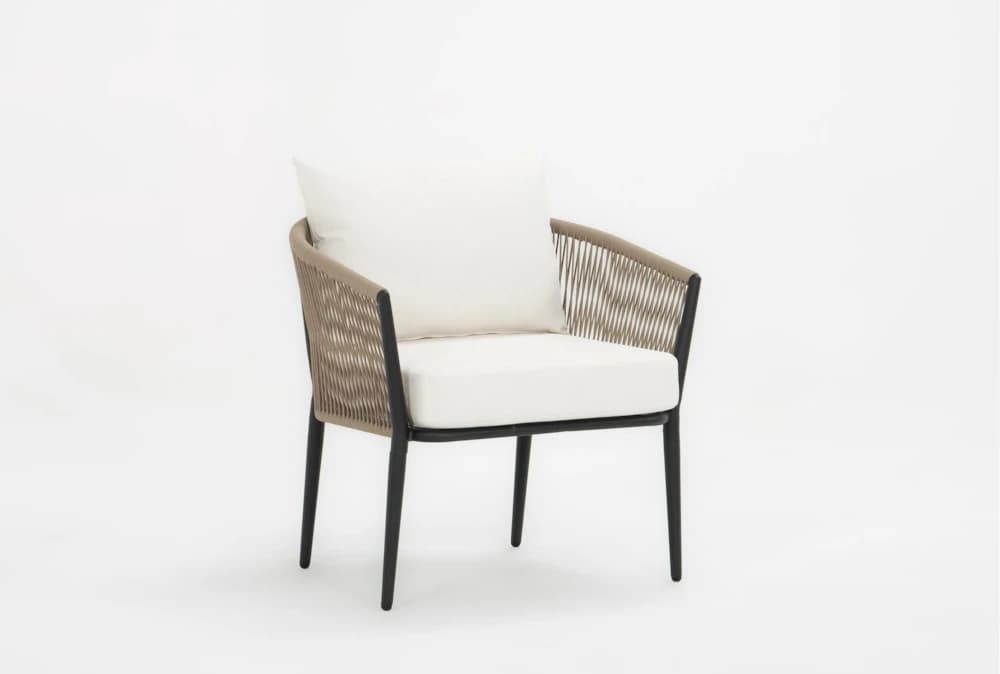 A modern outdoor armchair featuring a black metal frame, woven light brown rope back and armrests, and plush white seat and back cushions. The chair has a sleek, contemporary design with tapered legs. — 3D model