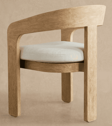 A contemporary dining armchair featuring a solid wood frame with a light, natural finish and visible grain. It has a distinctive curved backrest that seamlessly transitions into integrated armrests. The seat is upholstered with a light-colored, textured fabric cushion. The legs are sturdy and straight, giving the chair a minimalist yet robust appearance. — 3D model