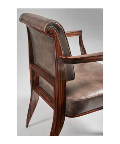 A sophisticated armchair featuring an exposed dark brown wood frame and rich grey-brown leather upholstery. The chair has subtly curved armrests and tapered legs, with polished metallic caps on the feet, adding a touch of elegance. The seat and backrest are well-padded, providing comfort, while the visible wood grain enhances its natural appeal. The design blends classic elements with a transitional aesthetic, suitable for various interior styles. — 3D model