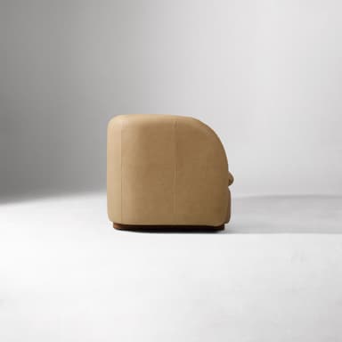 A contemporary two-seater loveseat upholstered in tan leather with a curved back and integrated armrests, resting on a dark wooden plinth base. — 3D model