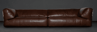 A contemporary two-seater sofa upholstered in brown leather. The sofa features a low profile with generously padded cushions for both the seat and back. Its arms are softly rounded and extend slightly outward from the main body. The overall design emphasizes comfort and a modern aesthetic, with a visible seam line dividing the two seat cushions. — 3D model
