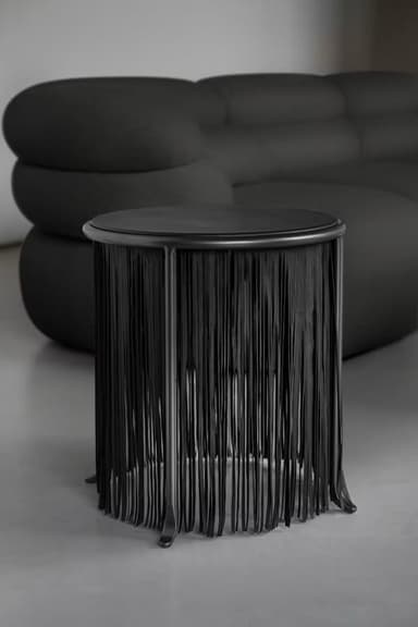A black round table featuring a unique fringe-like design for its base, supported by three subtle feet. — 3D model