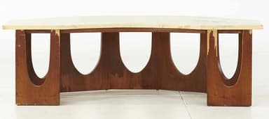 A coffee table with a light-colored, possibly marble or laminate, rectangular top with slightly beveled edges. The base consists of four vertical wooden elements, each with a large, semicircular cutout, arranged in a staggered pattern to form a visually open support structure. The wooden elements are dark brown and appear to be wood. — 3D model