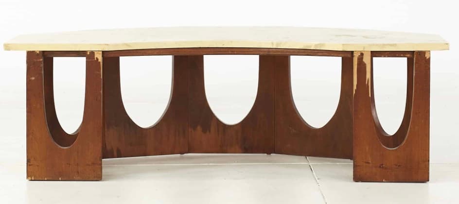 A coffee table with a light-colored, possibly marble or laminate, rectangular top with slightly beveled edges. The base consists of four vertical wooden elements, each with a large, semicircular cutout, arranged in a staggered pattern to form a visually open support structure. The wooden elements are dark brown and appear to be wood. — 3D model