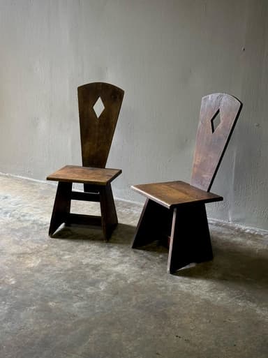 A small, dark-stained solid wood chair featuring a flat square seat and a tall, tapering backrest with a central diamond-shaped cutout. The chair has a rustic yet minimalist aesthetic. — 3D model