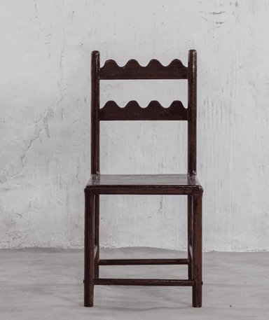 A dark-stained wooden chair featuring a distinctive backrest with two horizontal slats, each carved with a wavy or scalloped edge. It has a simple square wooden seat and straight legs with stretchers. — 3D model