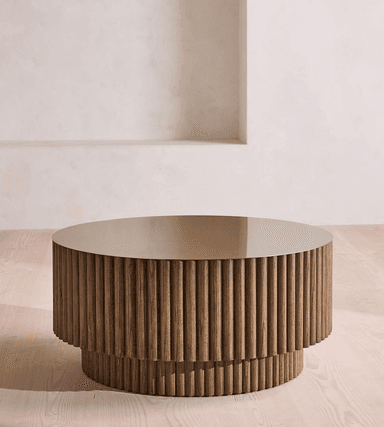 A round coffee table with a fluted base and a flat, circular top. The base consists of two stacked tiers, each featuring vertical, cylindrical wooden elements arranged closely together. The top surface is a solid, flat disc. — 3D model